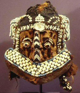 Elaborate African cultural mask featuring cowrie shell decoration and embellishment.
